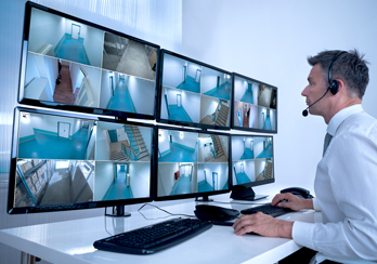 A security official monitoring surveillance cameras