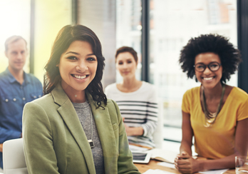Four co-workers smiling during a meeting