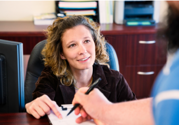 A woman consulting another person on the registration process