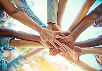 A group of people putting their hands together 