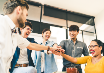 A group of employees putting their hands together as a symbol of teamwork