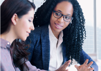 Two women discussing a business deal