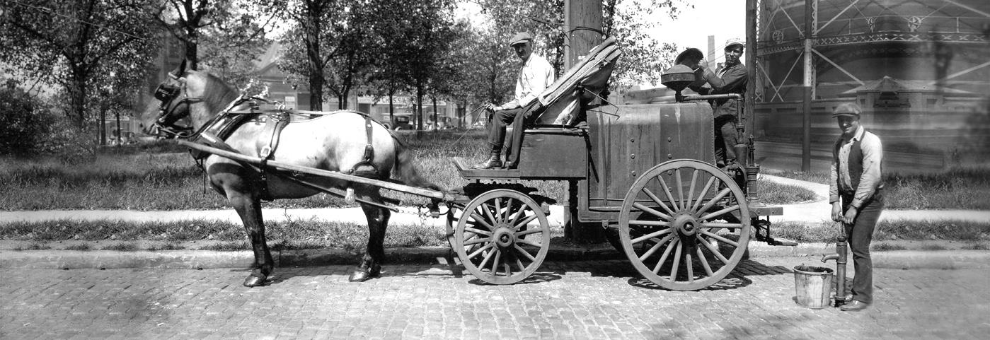 Public Service Employee pose with a horse drawn wagon