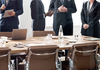 Executives talking with each other on the side of a board room table