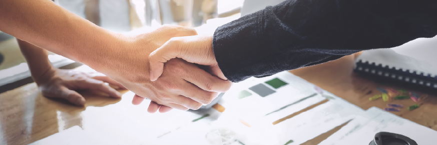 Two people shaking hands after a business deal