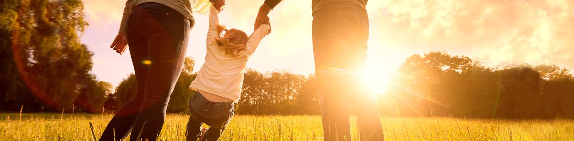 Mother and father playing with child during sunset