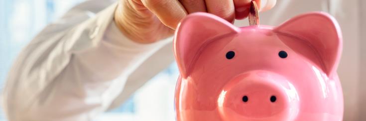Person putting money into a piggy bank