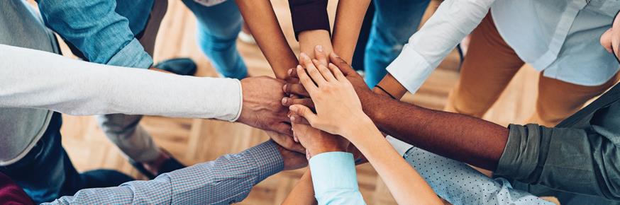 Various people touching hands.