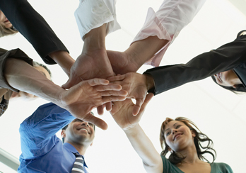 A team of people putting their hands together