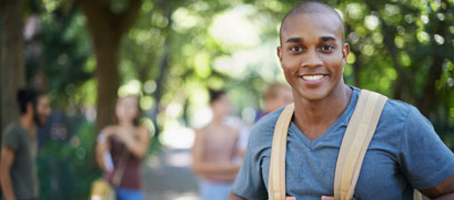 College student is shown, wearing a back pack on campus.