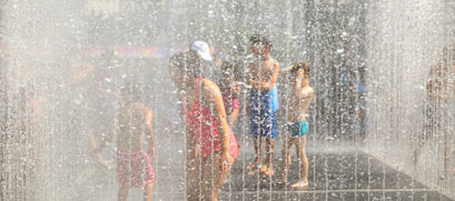 Children playing in a water park during a heat wave.